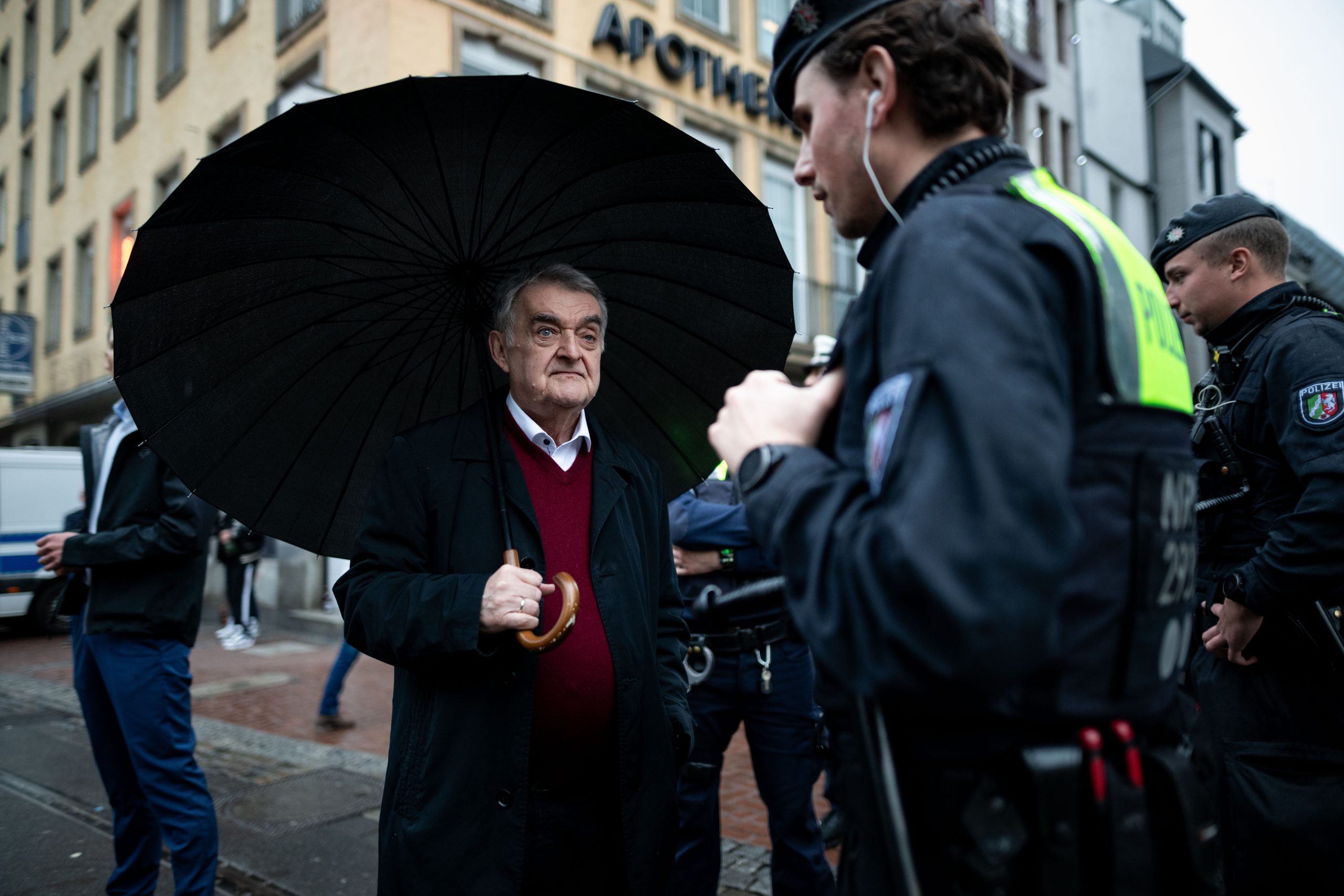 Herbert Reul (CDU,M), Innenminister von Nordrhein-Westfalen, spricht mit Beamten vor Ort. Die Ermittler wollen mehr über die Geschäfte einflussreicher Familienclans im Sicherheits- und Bewachungsgewerbe herausfinden. Foto: Fabian Strauch/dpa